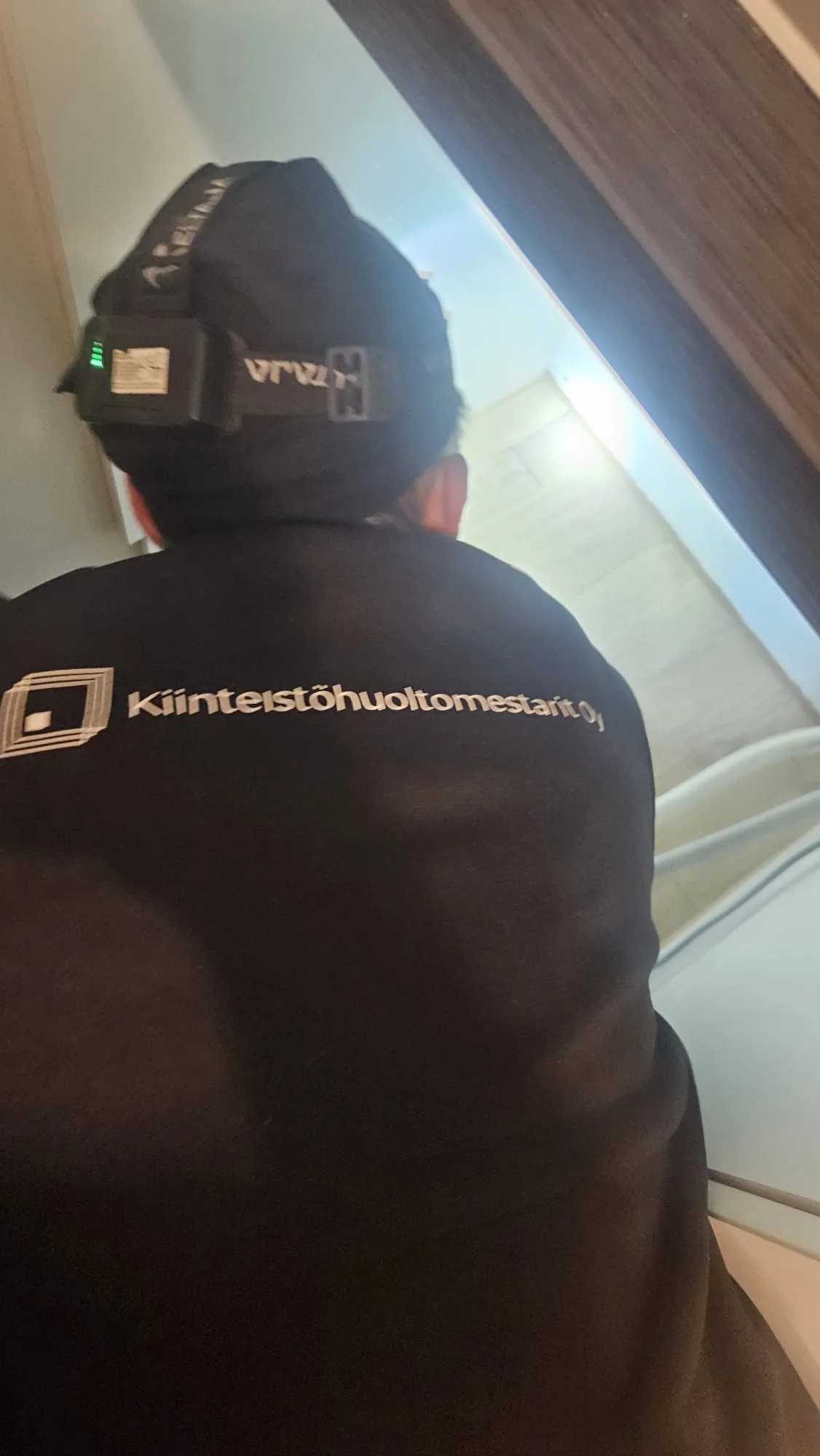 Kiinteistöhuoltomestarit-hupparinen asentaja työssä